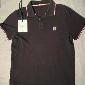 Moncler Maglia Polo - Riktigt snygg Moncler Piké i nyskick, 9/10. Nypris ligger på 3500 kr och alla OG tags ingår till pikén! Storleken är XL men den passar M-L bättre. Skicket är ännu bättre än vad som syns på bilderna. Hör av er vid funderingar!