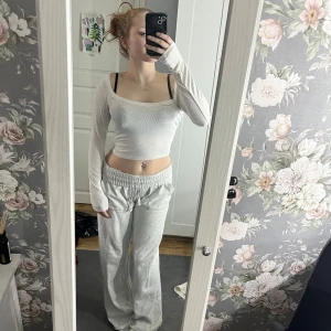 Vit långärmad topp - Säljer en vit långärmad topp med en tight passform. Toppen har en enkel design och är perfekt för en stilren look. Den är tillverkad i ett mjukt material som sitter skönt mot huden.