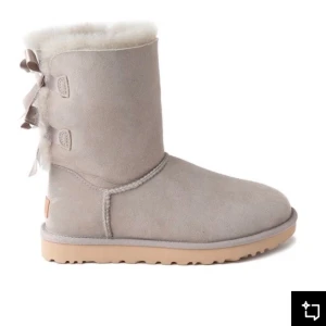 UGG Bailey stl. 41 - Säljer ett par ljusgrå UGGs med fina rosetter på baksidan. Fortfarande i mycket gott skick men med lite creasing. Pälsen är fortfarande mjuk och fluffig :)  Köptes för 3 150 kr