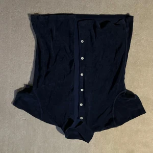 Mörkblå kofta från East West - Säljer en stilren mörkblå skjorta från East West. Den har korta ärmar och knappar framtill. Perfekt för en avslappnad look.