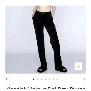 Svarta juicy couture med snörning - Snygga svarta juicy couture med snörning i midjan. Byxorna har en avslappnad passform och är perfekta för en bekväm stil. De har fickor framtill och en diskret logga på sidan.