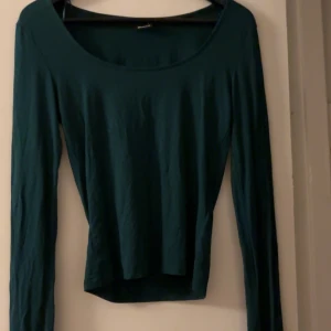 Mörkgrön långärmad topp från Gina - Snygg mörkgrön långärmad topp från Gina. Storlek S