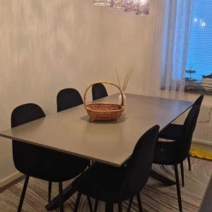 Matbord med svarta stolar - Modernt matbord med sex svarta stolar. Bordet har en stilren design med en ljus bordsskiva och svarta ben. Stolarna är klädda i svart tyg och har smala ben. Perfekt för en elegant matsal eller kök. 