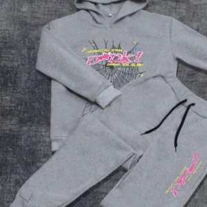 Grå hoodie med tryck - Säljer en grå hoodie med färgglatt tryck och spindelnätsdesign. Perfekt för en avslappnad stil med en cool twist. Hoodien har långa ärmar och en bekväm passform. Jag har storlekar i 13 års ålder, 14 års ålder, 15 års ålder och 16 års ålder