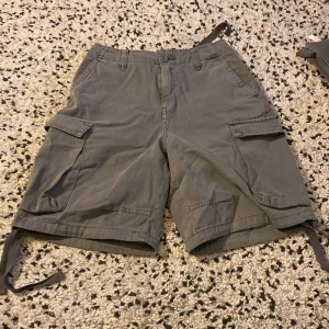 Gråa cargo shorts  - Ett par gråa cargo shorts från Pull & Bear. De har band på benen och midjan som kan tajtas. De är i mycket bra skick.