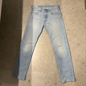 Ljusblå Levis 501 jeans - Säljer ett par klassiska ljusblå Levis 501 jeans. De har en straight passform och är tillverkade i slitstarkt denim. Perfekta för en avslappnad stil.