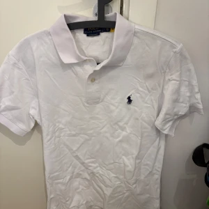 Ralph Lauren piké - Säljer en klassisk vit pikétröja från Ralph Lauren i custom slim fit. Storlek S. Mycket bra skick