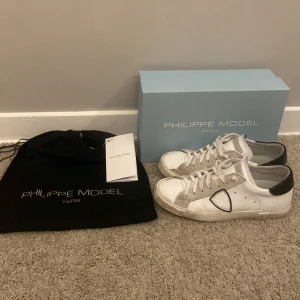 Vita sneakers från Philippe Model - Tja! Säljer ett par skitsnygga vita sneakers från Philippe Model med svarta detaljer och snörning. De är bara använda i 1 vecka och de är riktigt bra skick!