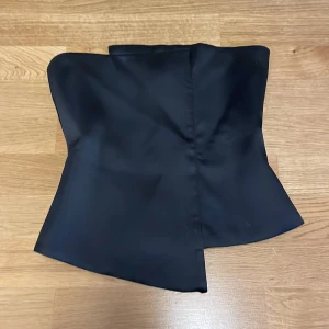 Svart korsettopp - Elegant svart korsettopp med dragkedja i ryggen. Perfekt för utgång! Aldrig använd och är i storlke XS. Priset ligger på 90 kr exslusive frakt.