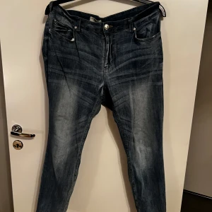 Mörkblå jeans från Denim - Snygga mörkblå jeans från Denim med klassisk femficksdesign och knappgylf. Perfekta för en avslappnad stil. Märkesdetaljer på baksidan ger en autentisk känsla.