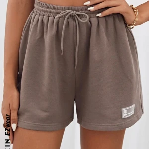 Bruna mjukisshorts - Säljer ett par bekväma bruna shorts. De har en elastisk midja med snörning för justerbar passform och en liten logga på benet. Använda en gång