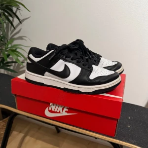 Ett par äkta Nike Dunk i svart och vitt -  Nike Dunk sneakers i klassisk svart och vit färgkombination. Skorna har används men fortfarande ett mycket bra skick! Hör gärna av dig för intresse och frågor. Priser kan alltid diskuteras! 😊köpta i kicks and stuff i Göteborg för 2999kr 