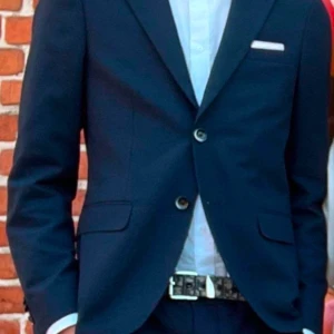 Mörkblå kostym Riley - Snygg mörkblå kostym med klassisk design och två knappar framtill. Använd vid två tillfällen och kemtvättad. 
