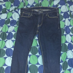 Mörkblå jeans från Emporio Armani - Snygga mörkblå jeans från Emporio Armani med klassisk femficksdesign och kontrasterande sömmar. Byxorna har en läderpatch med logotyp baktill och en normal passform. Perfekta för en stilren look. Storlek W: 28 L:30 det blir storlek Xs