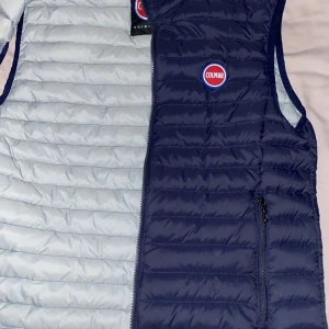 Blå dunväst från Colmar - Snygg blå dunväst från Colmar med dragkedja och logotyp på bröstet. Perfekt för kyligare dagar med sin quiltade design och praktiska fickor.