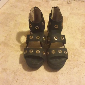 Svarta sandaler med nitar - Snygga svarta sandaler med coola nitar och öppen tå. De har en bekväm passform och dragkedja bak för enkel på- och avtagning. Perfekta för sommarens alla äventyr och fester!