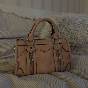 Väska  - Säljer denna väska då den aldrig kommer till användning. Helt ny och aldrig använd. Säljer den till de priset då den inte är äkta men ser exakt ut som originalet. Kom privat för frågor eller bilder:)( medföljer så man kan göra väskan lång)