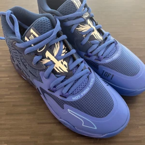 Blå basket sneakers från Puma - Säljer ett par coola blå basket sneakers från Puma, Puma LaMelo Ball MB.01 Team Blazing Blue. Skorna har ett unikt mönster och snörning framtill. Perfekta för både spel och vardag. De är i nyskick och redo för nya äventyr!
