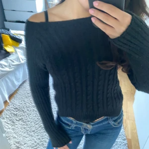 Svart ribbad tröja - Säljer en snygg svart ribbad tröja med lång ärm. Den är croppad och har en offshoulder-design som ger en trendig look. Perfekt för höst och vinter, och passar både till vardags och fest. Supermjuk och bekväm!