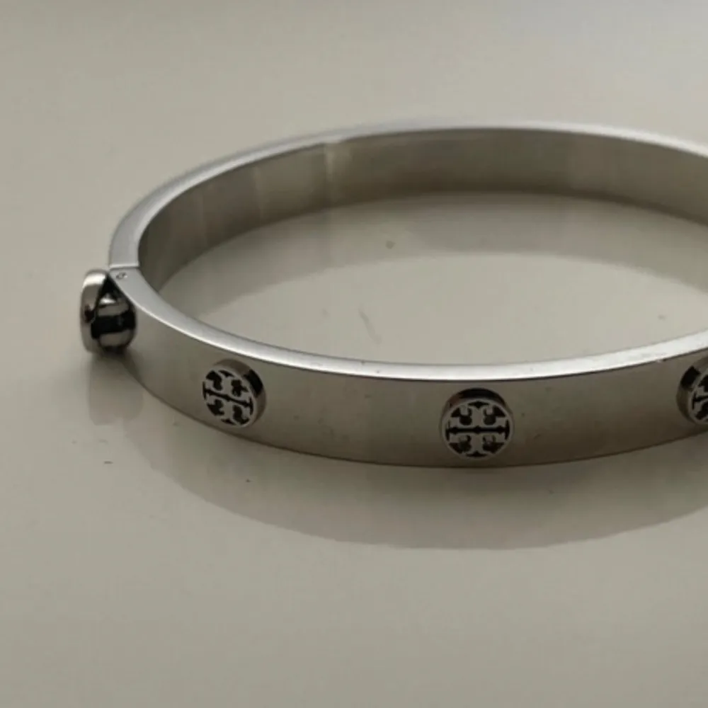 Modell: MILLER STUD HINGE BRACELET, 7MM OBS: aldrig använt! Inga tecken på slitage. Fick detta i present så kvitto saknas. Material: ädelstål Nypris Tory Burch: 2500kr. Asusteet.