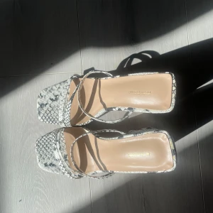 PLT klackar - Högklackar i vit ormskinn design från Pretty Little Thing. Väldig snål använd och i mycket bra skick.  (Frakt tillkommer, i andra finns möjlighet att mötas upp i Stockholm)