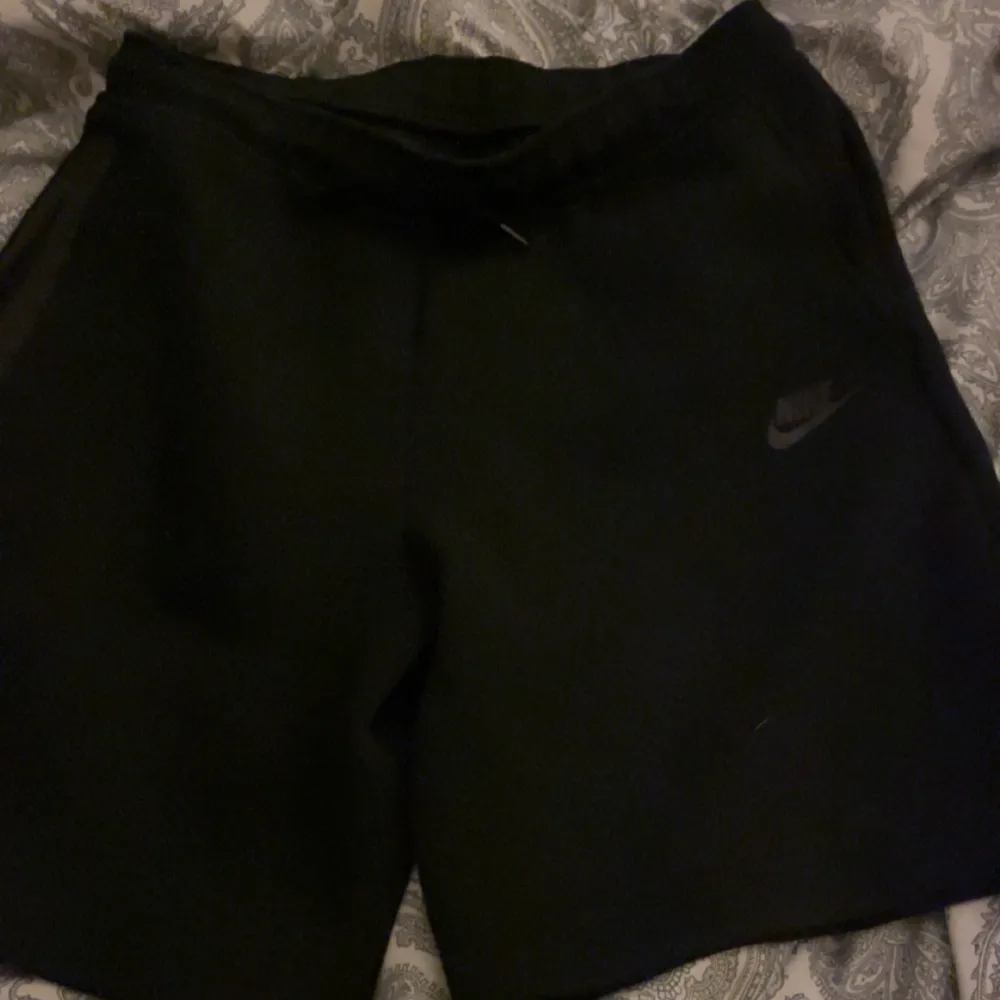 Säljer ett par svarta shorts från Nike i storlek M. De är perfekta för träning eller en avslappnad dag. Shortsen har en enkel design med Nike-loggan på sidan. De är gjorda i ett bekvämt material som känns skönt mot huden.. Shorts.