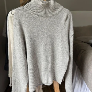 Grå stickad polotröja från Gina Tricot - Säljer en supermysig grå stickad polotröja från Gina Tricot i storlek XS, passar även S. Tröjan har en ribbad kant vid ärmslut och nederkant, samt slits på båda sidor som ger en snygg detalj. Passar perfekt till höst och vinter🍂❄️Aldrig använd!