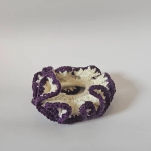 Handgjord virkad scrunchie i lila och vit - Superfin handgjord scrunchie som är virkad i lila och vit. Perfekt för att piffa upp vilken frisyr som helst! Den är elastisk och passar de flesta hårtyper. Perfekt accessoar för både vardag och fest.