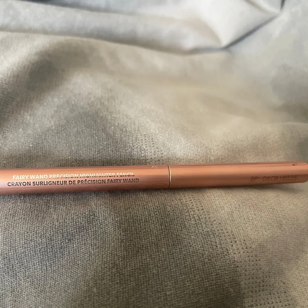 Säljer en Sheglam Fairy Wand Precision Highlighter Pencil i en snygg roséguld nyans. Perfekt för att ge ditt ansikte en subtil glöd och highlighta dina bästa drag. Pennan är smidig att använda och lätt att ta med i väskan. Perfekt för både vardag och fest!. Skönhet.