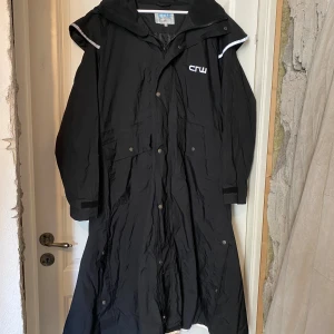 CRW ridjacka - Lång ridjacka med massa olika knappar beroende på hur mycket man vill att den ska expandera. En innerficka och två yttre fickor på framsidan. 💕 Superbra skick, ska såklart tvätta den innan försäljning.