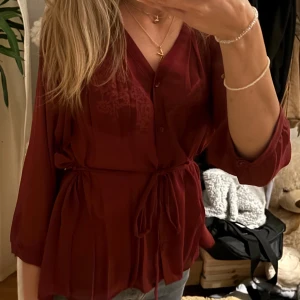 En verkligen super fin vinröd blus - En super fin vinröd blus som passar både till vardags eller till fest. Men knyter den antingen bak eller fram☺️Fint skick, köp gärn vi köp nu, men skriv till mig först, skriv även om du har några frågor❤️