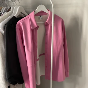 Rosa skjorta i skinn-imitation  - Skjorta från visual Clothing Project. Mycket bra skick få endast använd 2-3 gånger. Storlek XS. Något oversize. 