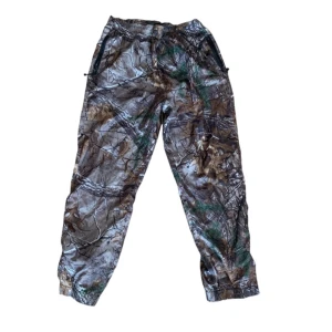 Camouflagebyxor från Stussy - Säljer ett par coola camouflagebyxor från Stussy i storlek L. Byxorna är tillverkade i 100% polyester . De har en elastisk midja för extra komfort och är fodrade. Perfekt för att skapa en intressant outfit till höst!👍