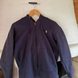 Polo Ralph lauren hoodie - Jag säljer en poloralphlauren hoodie blå i storlek S då den va för liten när jag fick den, tröjan har solblekning och därför kan priset sänkas men annars i bra skick