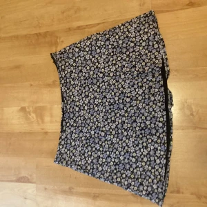 Blommig minikjol H&M - Söt minikjol i storlek 42 från H&M. Svart med blåa små blommor. Skriv gärna vid frågor 💕