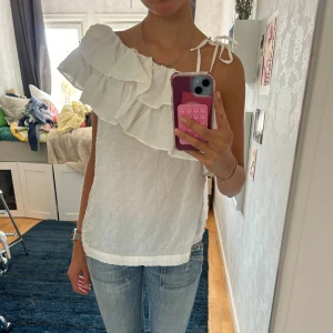 Blus med volanger - Säljer denna blus med volanger. Man kan knyta så att den sitter på båda axlarna eller ha den oneshoulder 💞💞