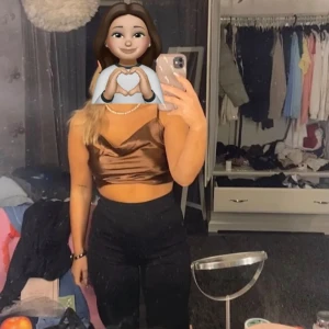 Brun satinlinne - Säljer ett snyggt brunt satinlinne med smala axelband som är justerbara. Perfekt för festliga tillfällen eller en utekväll. Linnet har en glansig finish som ger en lyxig känsla.