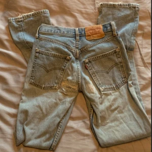 low-rise levis jeans - Supergulliga ripped lågmidjade jeans från Levis! Ärvde dem så tyvärr vet jag inte storleken men skulle gissa på 32. De har en liten fläck, men det är inte så märkbart.