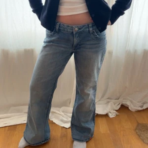 Snygga bootcut blå jeans med broderade fickor - Snygga blå jeans med broderade detaljer på bakfickorna. De har en klassisk femficksdesign och en bekväm passform. Perfekta för en avslappnad stil.