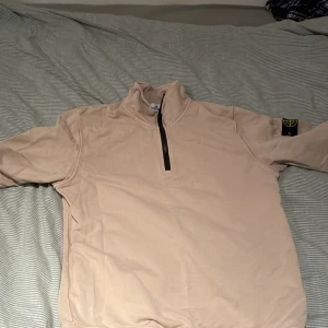 Beige tröja med dragkedja från Stone Island - Säljer en beige tröja från Stone Island med halv dragkedja och långärmad design.  Storlek S passar runt 165cm. Ny pris ca 3000
