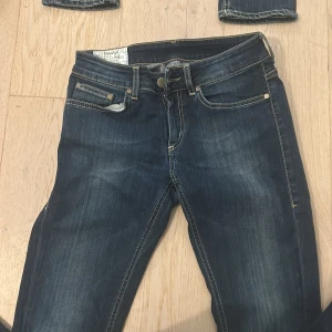 Mörkblå jeans från Dondup - Snygga mörkblå jeans från Dondup med klassisk femficksdesign och kontrastsömmar. Jeansen har en knappgylf och är tillverkade i en bomullsblandning för extra komfort. Perfekta för en avslappnad stil.
