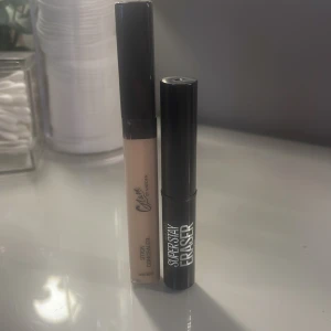 Concealer och läppstiftbortagare från olika märken - Säljer en flytande concealer i ljus nyans med applikator och ett läppstift i en kompakt svart hylsa. Concealern är perfekt för att täcka ojämnheter och läppstiftet ger en långvarig färg.