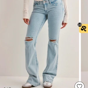 nelly jeans  - Snygga ljusblå bootcut jeans med slitningar på knäna och coola broderade detaljer på bakfickorna. lowwaist och långa i benen, säljes pga används ej. endast testade , nypris 699kr
