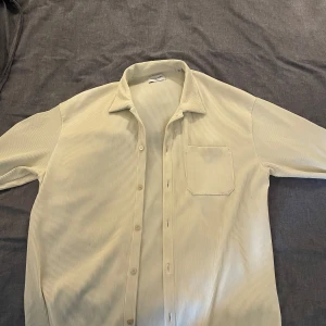 Beige randig skjorta från Jack & Jones - Säljer en stilren beige skjorta från Jack & Jones med diskreta ränder. Skjortan har korta ärmar och en klassisk krage. Perfekt för en avslappnad stil. 