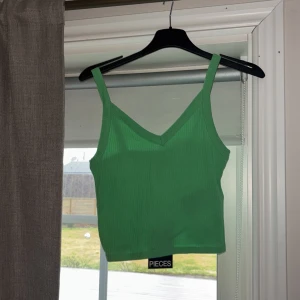 Grönt linne från Vero Moda  - Säljer en snygg grön ribbad linnetopp från Pieces. Aldrig använd och prislappen är fortfarande kvar