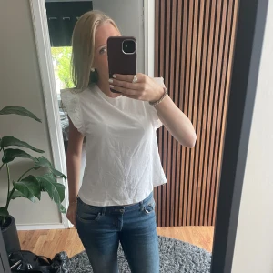 Vit blus från MNG - Säljer en söt vit blus från MNG (mango) med volangdetaljer på ärmarna. Perfekt för en stilren, enkel och söt look💕Använd men inga defekter.
