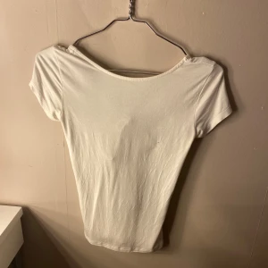 Vit och svart kortärmad topp - Två stilrena toppar i vitt och svart med korta ärmar. Den vita toppen har en knytning framtill som ger en söt detalj. Perfekta basplagg för garderoben.       Knappt använda, säljer då dom bara hänger i garderoben. Säljer en för 50kr båda för 100kr. Normal i storlek. OBS! Jag har även lagt ut annonsen på Vinted också