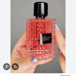 Admiration Eternal Parfym - En elegant parfymflaska med en unik, fyrkantig design och ett mönster av små kuber. Flaskan är genomskinlig med en rosa vätska inuti och har en svart etikett med texten 'Admiration Eternal'. Korken är svart och stilren.