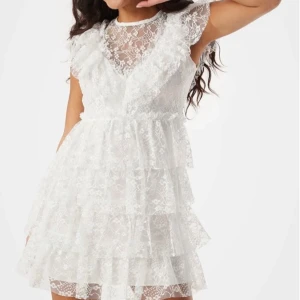 Vit spetsklänning med volanger - Säljer nu min populära studentklänning i storlek S som är helt slutsåld i XS-L. Bara använd en gång på studenten och den är i super bra skick! Passar perfekt på mig som är en S/M. Pris kan diskuteras 