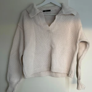 Stickad tröja med krage - Väldigt fin beige tröja. Dock trasig vid vänsterhanden (se sista bilden) därav sänkt pris. Annars bra skick.